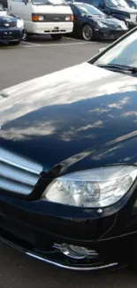 Sleek black car with reflective surface in showroom setting.