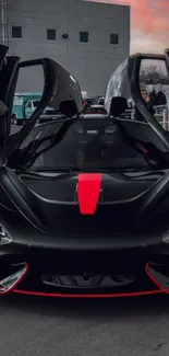 Black sports car with red accents at sunset