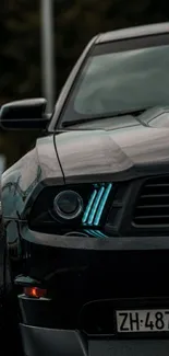 Mobile wallpaper of a sleek black car with blue headlights in the rain.