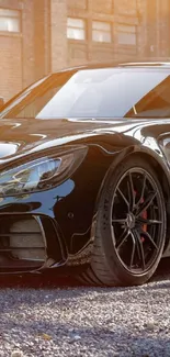 Sleek black sports car in urban setting, shimmering under sunlight.