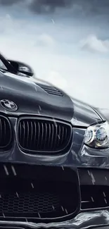 Sleek black sports car with raindrops on a dramatic background.