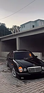 Sleek black luxury sedan in urban setting on pavement.