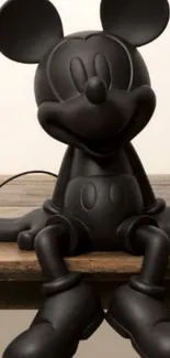 Sleek black cartoon figure on a wooden surface.