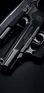 Two sleek black firearms on a dark background.