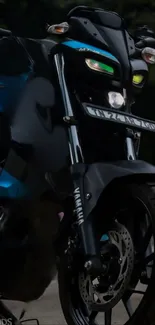 Front view of a sleek black motorcycle with illuminated headlights.