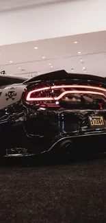 Black muscle car with sleek design and illuminated rear lights.