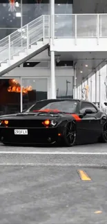 Sleek black muscle car in urban setting.