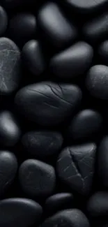 Black pebbles creating a smooth and natural phone wallpaper.