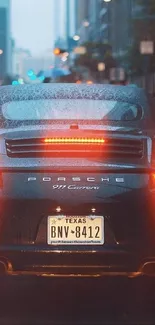 Rainy cityscape with Porsche 911 tail lights aglow.