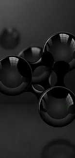 Sleek black spheres on dark background mobile wallpaper.