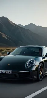 Black sports car on a mountain road with a scenic view.