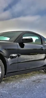 Sleek black sports car under dramatic cloudy sky.