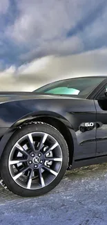 Sleek black sports car against a dramatic sky.