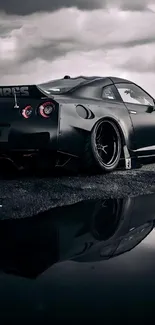 Sleek black sports car on a reflective surface with a moody sky backdrop.