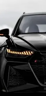 Sleek black sports car with LED headlights and grille.