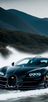 Sleek black sports car speeding on water with a mountain backdrop.