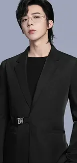 Person in sleek black suit on light gray background.