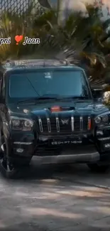 Black SUV parked outdoors with lush greenery.