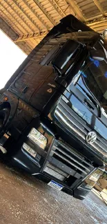 Sleek black Volkswagen truck under a roof.