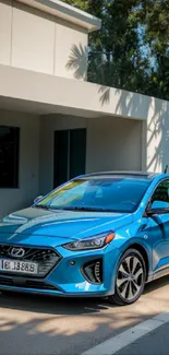 Blue car parked by a modern house on a sunny day.