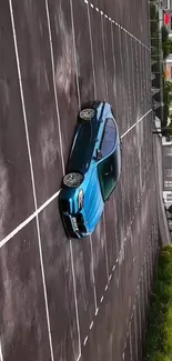 Blue sports car parked in an empty lot with urban backdrop.