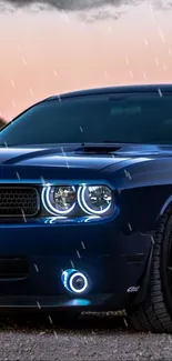 Sleek blue car with shining headlights in the rain.