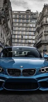 Sleek blue car on urban street with buildings.