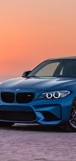 Blue sports car parked on beach at sunset.