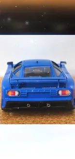 Sleek blue model car on textured surface wallpaper.