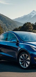 A sleek blue car with mountains in the background.