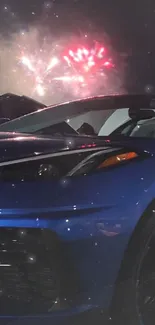 Blue sports car with fireworks in the night sky.