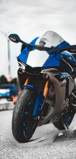 Dynamic blue motorcycle on road wallpaper with sleek design and modern aesthetics.