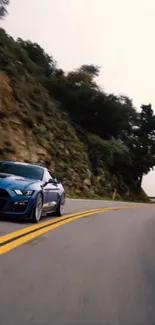 Blue sports car on a curvy mountain road.