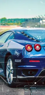 Sleek blue sports car on a racing track with a beautiful sky backdrop.