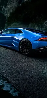 Sleek blue sports car on mountain road wallpaper.