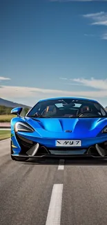 Blue sports car on open road under a clear sky.