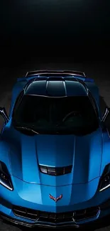 Top view of a sleek blue sports car in dim lighting.