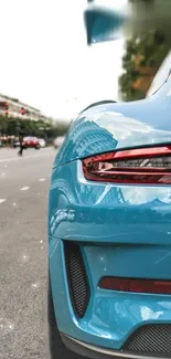 Sleek blue sports car on urban street wallpaper.