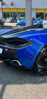 Blue sports car parked outside a showroom, showcasing sleek design.