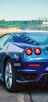 Sleek blue sports car on a racing track, perfect for mobile wallpaper.