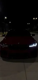 Sleek car with headlights on at night.