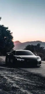 Sleek black car on open road at sunset, surrounded by nature.