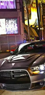 Sleek car parked in vibrant cityscape at night.