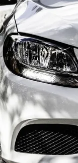 Sleek front view of a white luxury car under natural light.