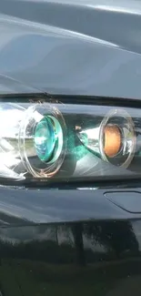 A sleek car headlight with reflections and a modern design in dark gray tones.