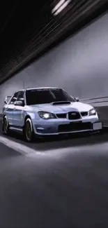 Sleek silver car driving through a tunnel at high speed.