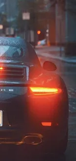 Sleek sports car on a rainy street with glowing taillights.