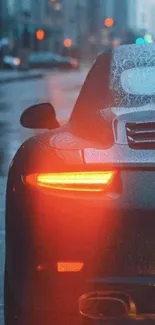 Sleek car with glowing taillights in a rainy urban setting.