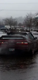 Sleek car driving on a rainy street with wet pavement.