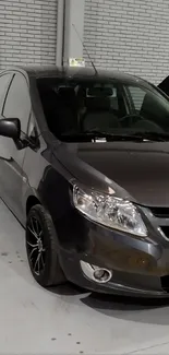 Sleek gray car parked in urban garage setting.